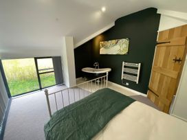 A bedroom with a bathtub and window at Hen Stablau in Dinmael near Cerrigydrudrion