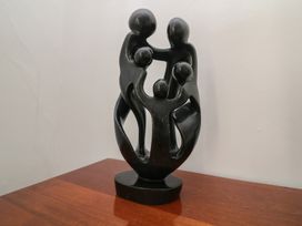 A sculpture representing family figures on a wooden surface at 36 Crowthers Hill Dartmoor