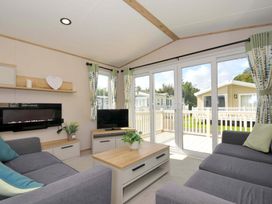 A living room with a sofa and television at Eden Way 47