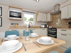 A kitchen with a stove and dining table set at Eden Way 47