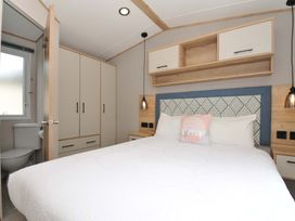 A bedroom with a bed and wardrobe at Eden Way 47