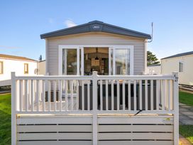 A mobile home with a deck at Eden Way 47 Par