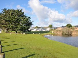 A view of a pond with trees and buildings at Eden Way 47 Par
