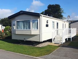 A static caravan with steps and decking at Par Sands Holiday Park - Par