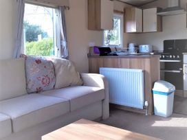 A living room with a sofa and kitchen unit at Par Sands Holiday Park - 6388 in Par