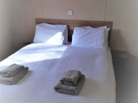 A bed with pillows and towels at Par Sands Holiday Park - Par