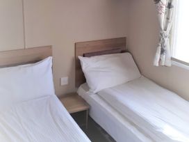 A bedroom with two single beds and a window at Par Sands Holiday Park - 6388, Par