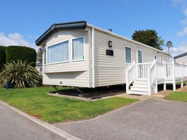 A static caravan with steps and a grassy area at The Oakley in Par