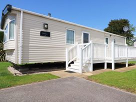 A mobile home with a deck and steps at The Oakley in Par