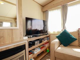 A living room with a television and entertainment unit at The Oakley in Par