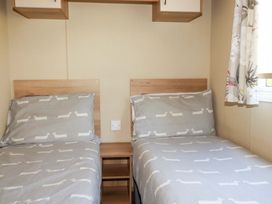 A bedroom with two beds and a bedside table at The Oakley in Par