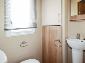 A bathroom with a toilet, sink, and storage cabinet at The Oakley in Par