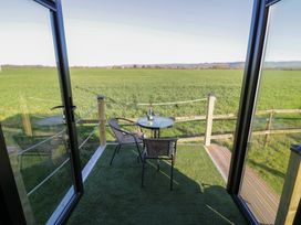An outdoor seating area with a table and chair overlooking a field at GiGi's Horsebox in Evesham