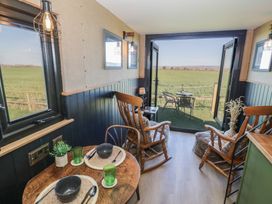 A living room with rocking chairs and a view of fields at GiGi's Horsebox in Evesham