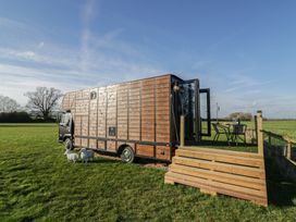 A horsebox with a table and chairs in front at GiGi's Horsebox in Evesham