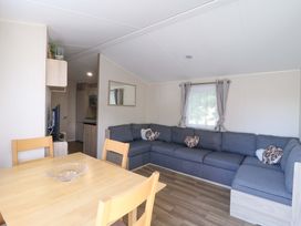 A living room with a sofa and table at Singh and Leite Family Caravan St. Osyth