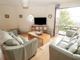 A living room with a television and sofas at Awel y Môr in Burry Port