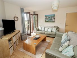 A living room with a sofa and coffee table at Awel y Môr in Burry Port
