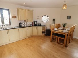 A kitchen with a dining table and chairs at Awel y Môr in Burry Port