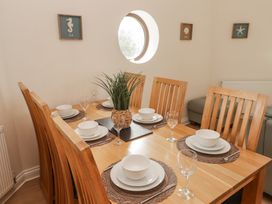 A dining room with a wooden table and chairs at Awel y Môr in Burry Port