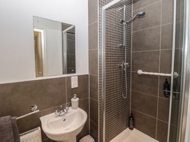 A bathroom with a shower and sink at Awel y Môr in Burry Port