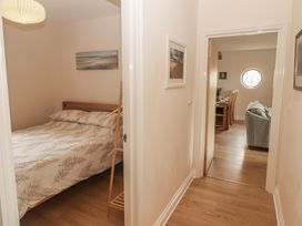 A bedroom with a bed and hallway leading to another room at Awel y Môr Burry Port