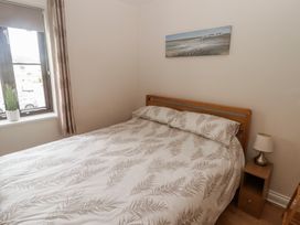 A bedroom with a bed and bedside table at Awel y Môr in Burry Port