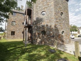 A building with a stone wall and windows at Awel y Môr in Burry Port