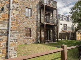 An outdoor area with stone walls and balconies at Awel y Môr Burry Port