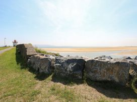 A view of a lighthouse and sandy beach at Awel y Môr in Burry Port