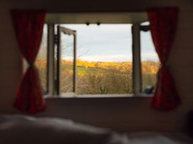 A window with open curtains and a view of a landscape at Goldfinch in Launceston