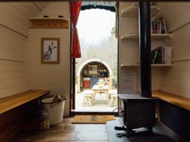 A living area featuring a wood stove and a view of a table outside at Goldfinch in Launceston