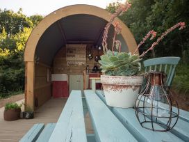 An outdoor living area with a wooden table and plants at Goldfinch in Launceston