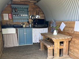 A kitchen with a wooden table and chairs at Goldfinch in Panson Mill near Ashwater