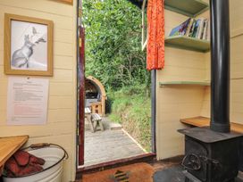 An interior view with a stove and shelf at Goldfinch Panson Mill near Ashwater