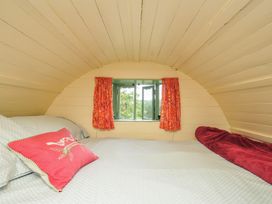 A bedroom with a bed and window at Goldfinch in Panson Mill near Ashwater