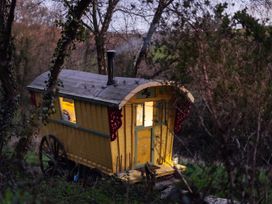A yellow caravan with a chimney in a rural setting at Prudence in Launceston