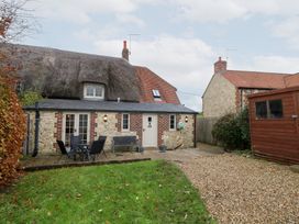 An outdoor view of a house with a garden and seating area at Bubbs Cottage 