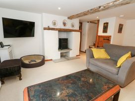 A living room with a fireplace and sofa at Bubbs Cottage