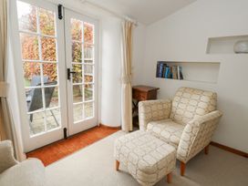 A snug with an armchair and footstool at Bubbs Cottage