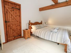 A bedroom with a bed and wooden door at Bubbs Cottage 