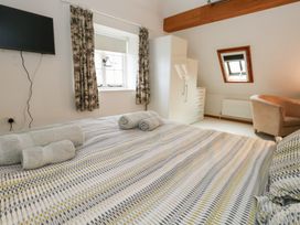 A bedroom with a bed and television at Bubbs Cottage