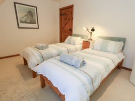 A bedroom with twin beds and a bedside table at Bubbs Cottage