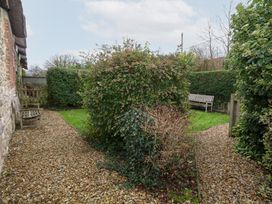 A garden with hedges and benches at Bubbs Cottage