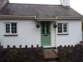 A house with a green door and windows at Bryn Bach in Pentraeth