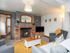 A living room with a fireplace and seating area at Bryn Bach in Pentraeth