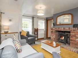 A living room with a fireplace and bookshelf at Bryn Bach in Pentraeth