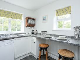 A kitchen with seating and dinnerware at Bryn Bach Pentraeth