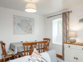 A dining room with a table and chairs at Bryn Bach in Pentraeth