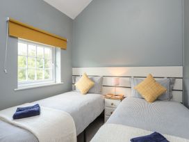 A bedroom with two beds and a window at Bryn Bach in Pentraeth